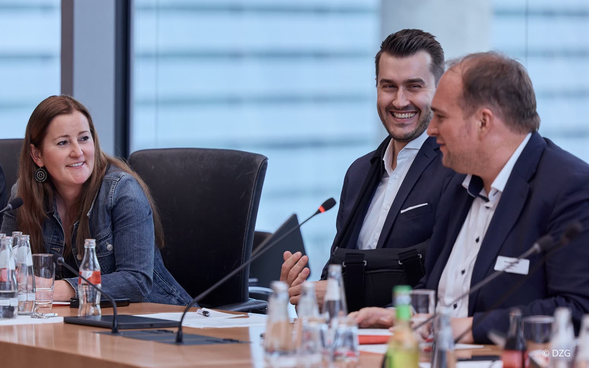Diskussionsteilnehmer Sebastian Roloff, Julian Joswig und Janine Wissler am Konferenztisch beim Gastwelt-Summit 2026 in Berlin.