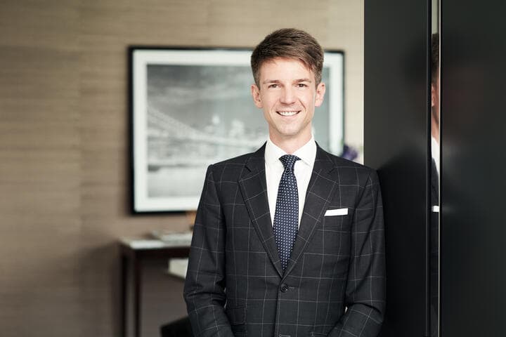 Andriy Semkiv, Geschäftsführer bei DAHLER Berlin, im Business-Anzug vor modernem Hintergrund