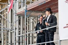Zwei Männer bei einer Ansprache auf einem Baugerüst beim Richtfest in Berlin-Karlshorst