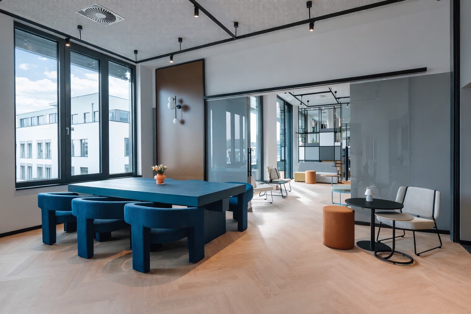 Lounge-Bereich im smartments Bielefeld mit moderner Einrichtung und großen Fenstern.