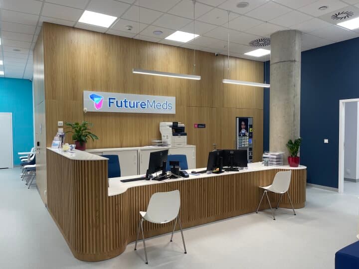Empfangsbereich von FutureMeds im Infinity-Gebäude in Wrocław, moderner Tresen mit Schildern und Computern