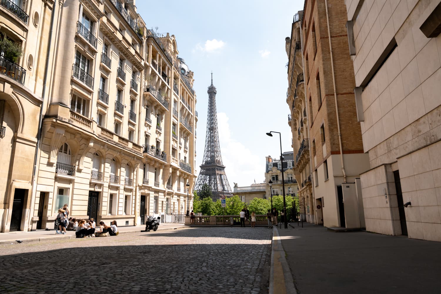 Straßenszene mit klassischen Pariser Wohnhäusern und Eiffelturm im Hintergrund im 16. Arrondissement, Paris.