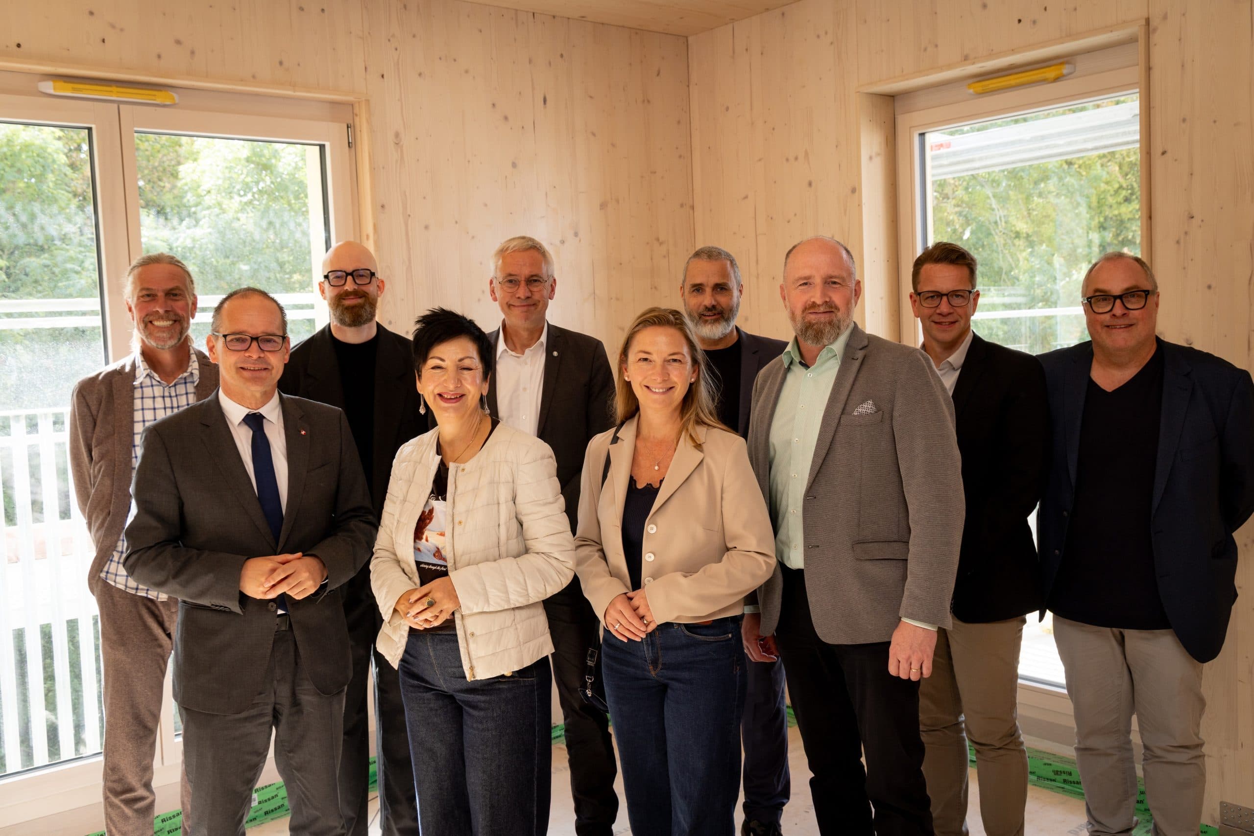 Gruppenfoto von Projektbeteiligten und Politikern beim Richtfest der Woodscraper in Wolfsburg