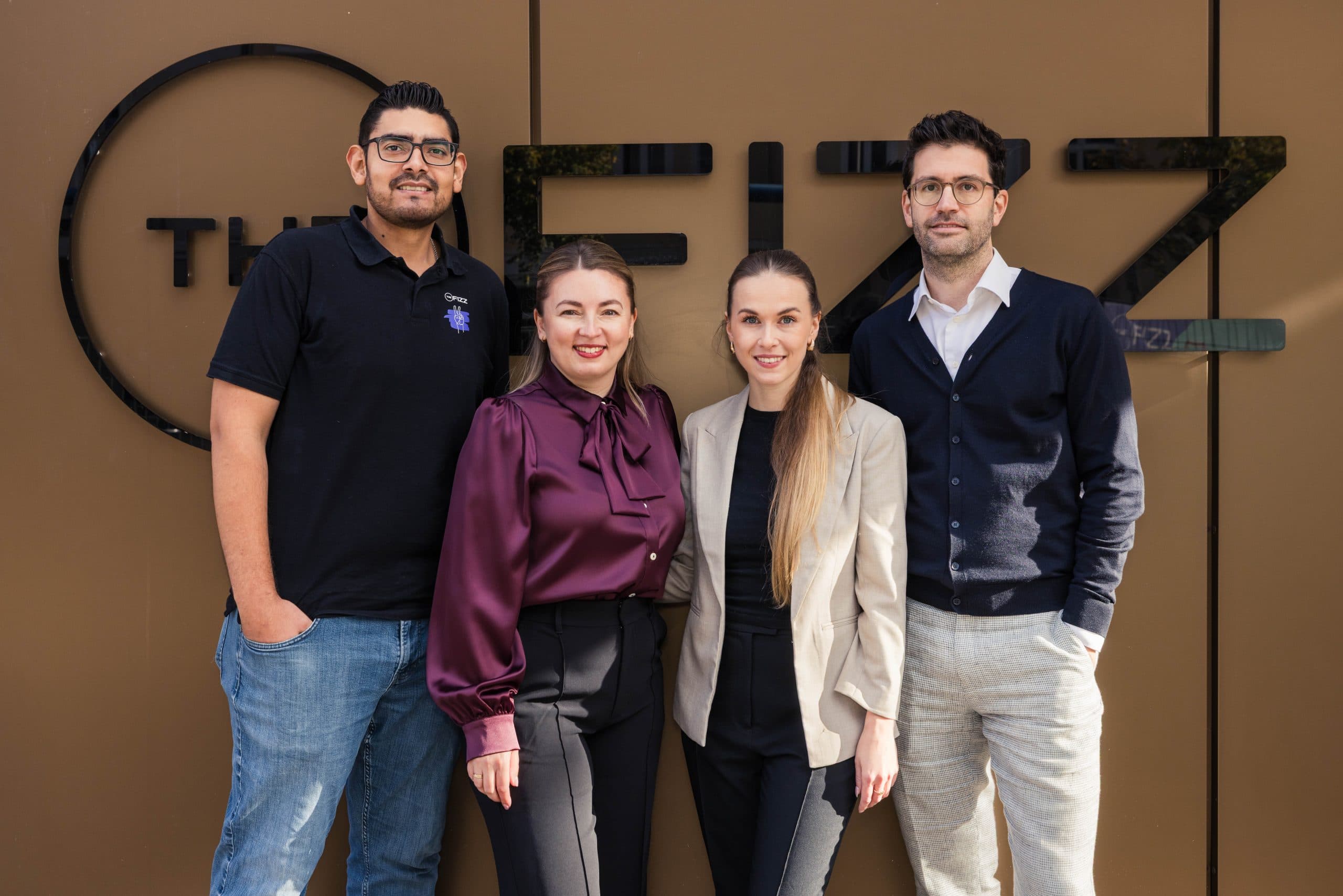 Vier Mitglieder des International Campus Teams stehen vor dem Schriftzug THE FIZZ in Berlin Friedrichshain.