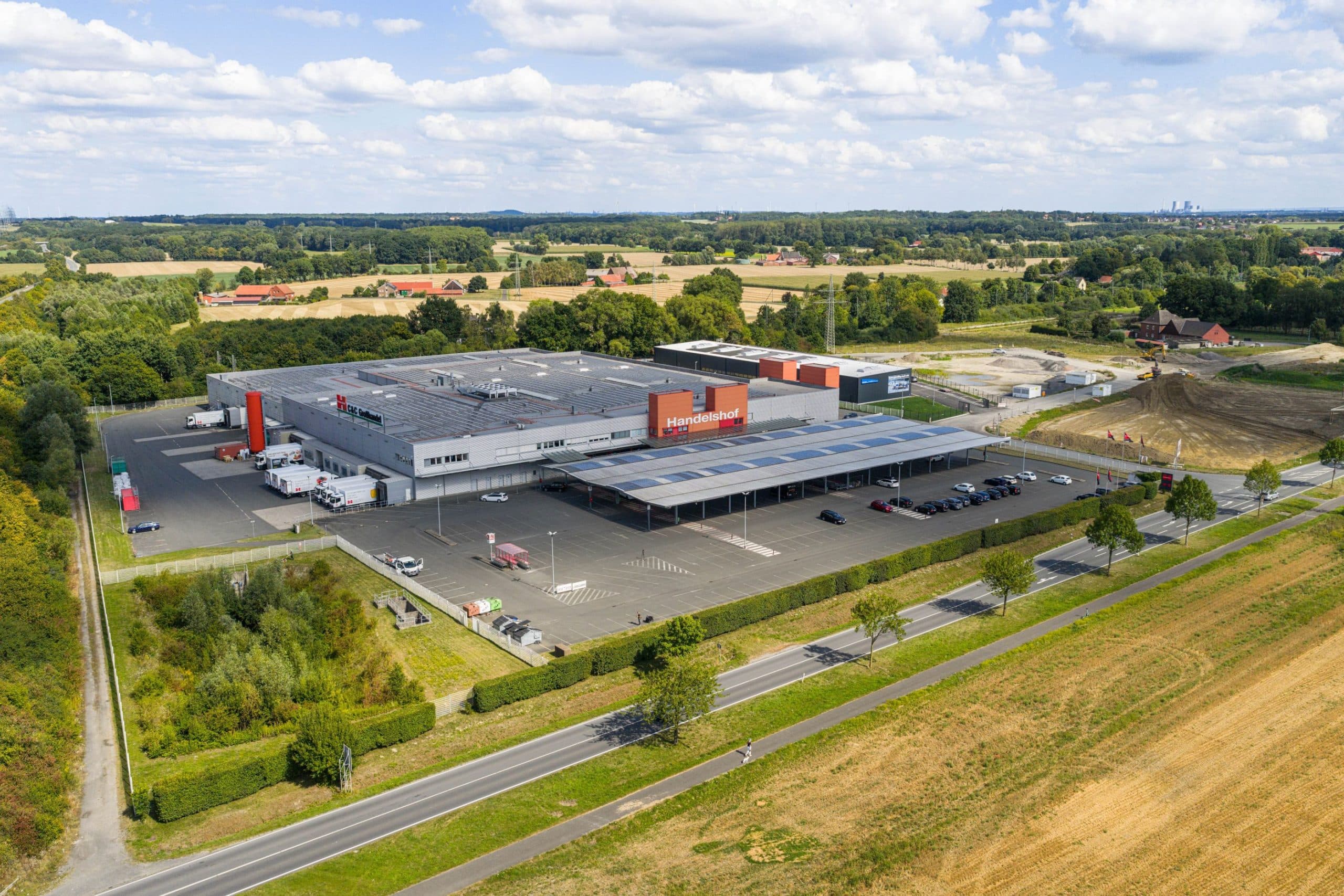 Außenansicht des Handelshof-Marktes in Hamm mit großem Parkplatz und Firmenlogo.
