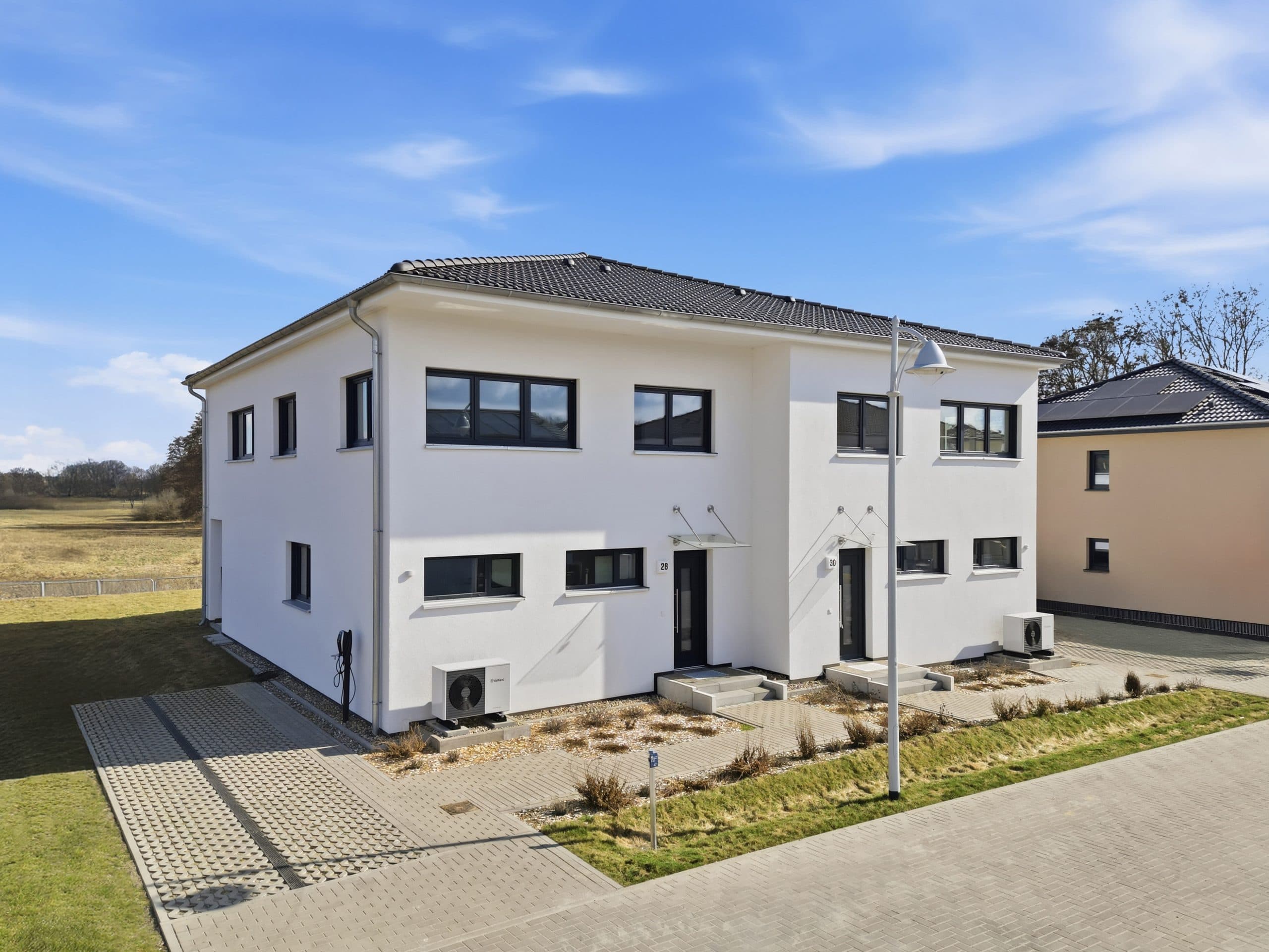 Frontalansicht eines modernen Doppelhauses im Wohnquartier in Beelitz, Potsdamer Umland.