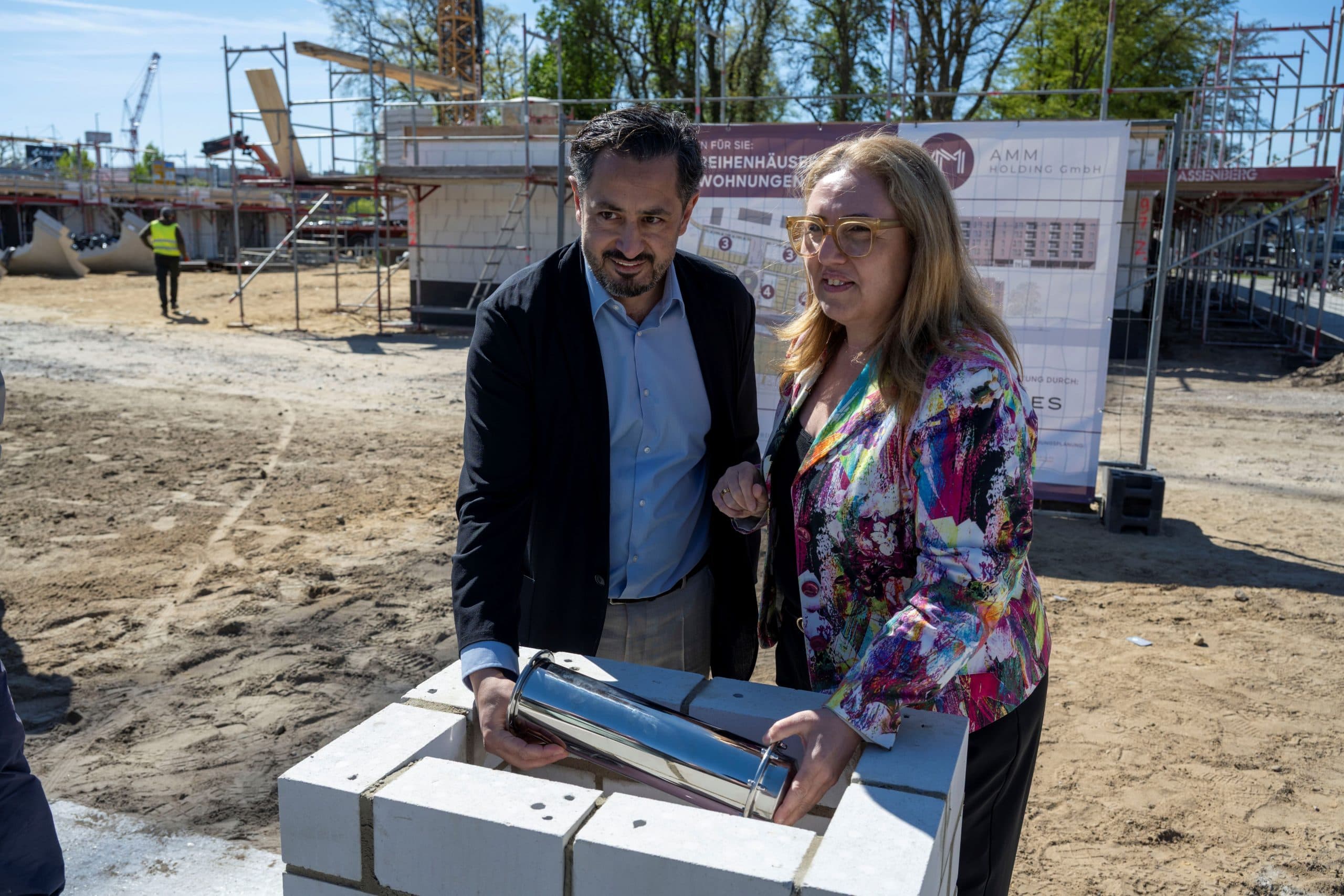 Grundsteinlegung für das Wohnquartier Maria-Buck in Bremen-Osterholz mit Özlem Ünsal und einem weiteren Beteiligten auf der Baustelle.