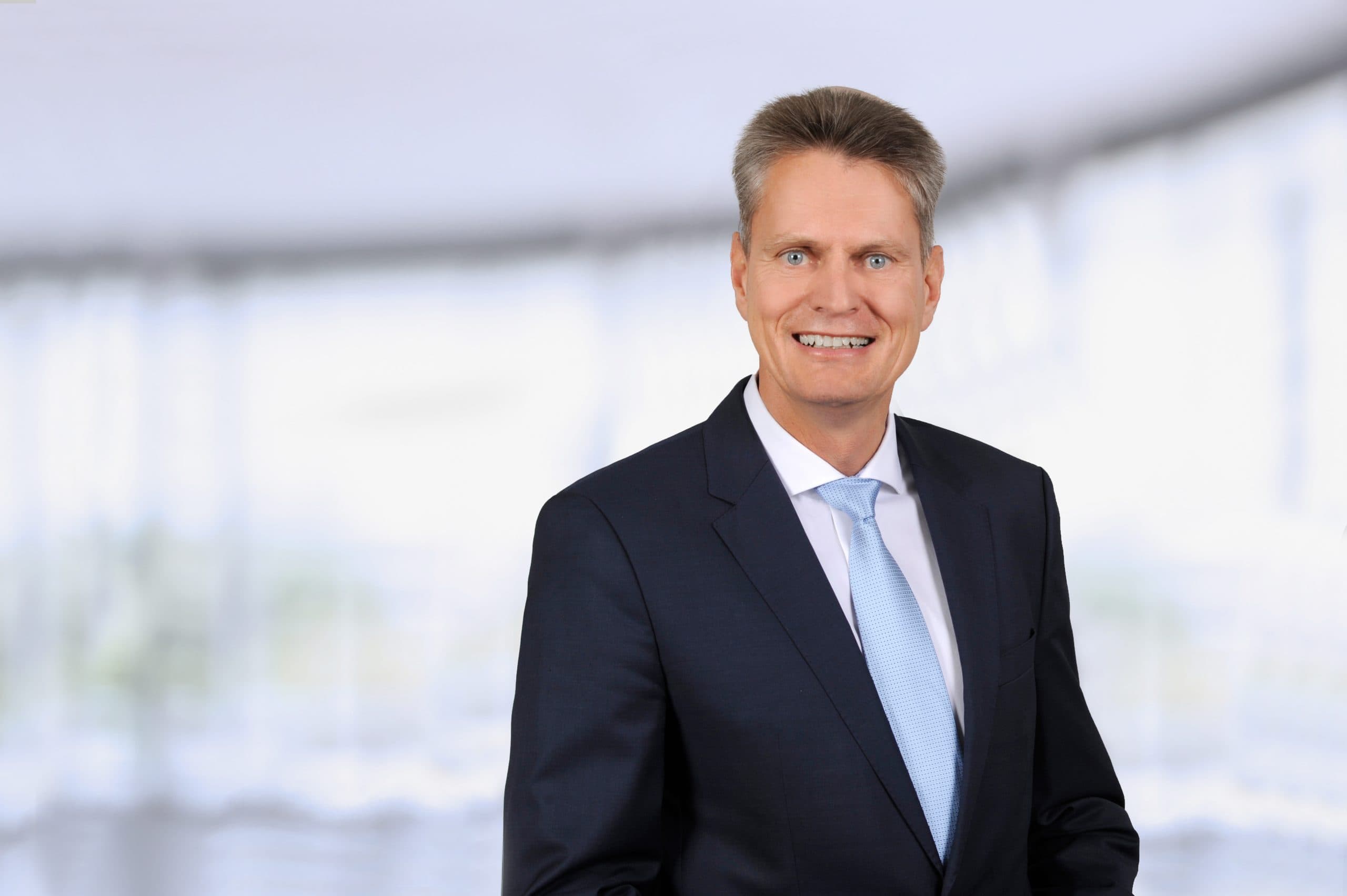 Porträt von Gerhard Lehner, Head of Germany bei Savills Investment Management, im Anzug vor unscharfem Hintergrund.
