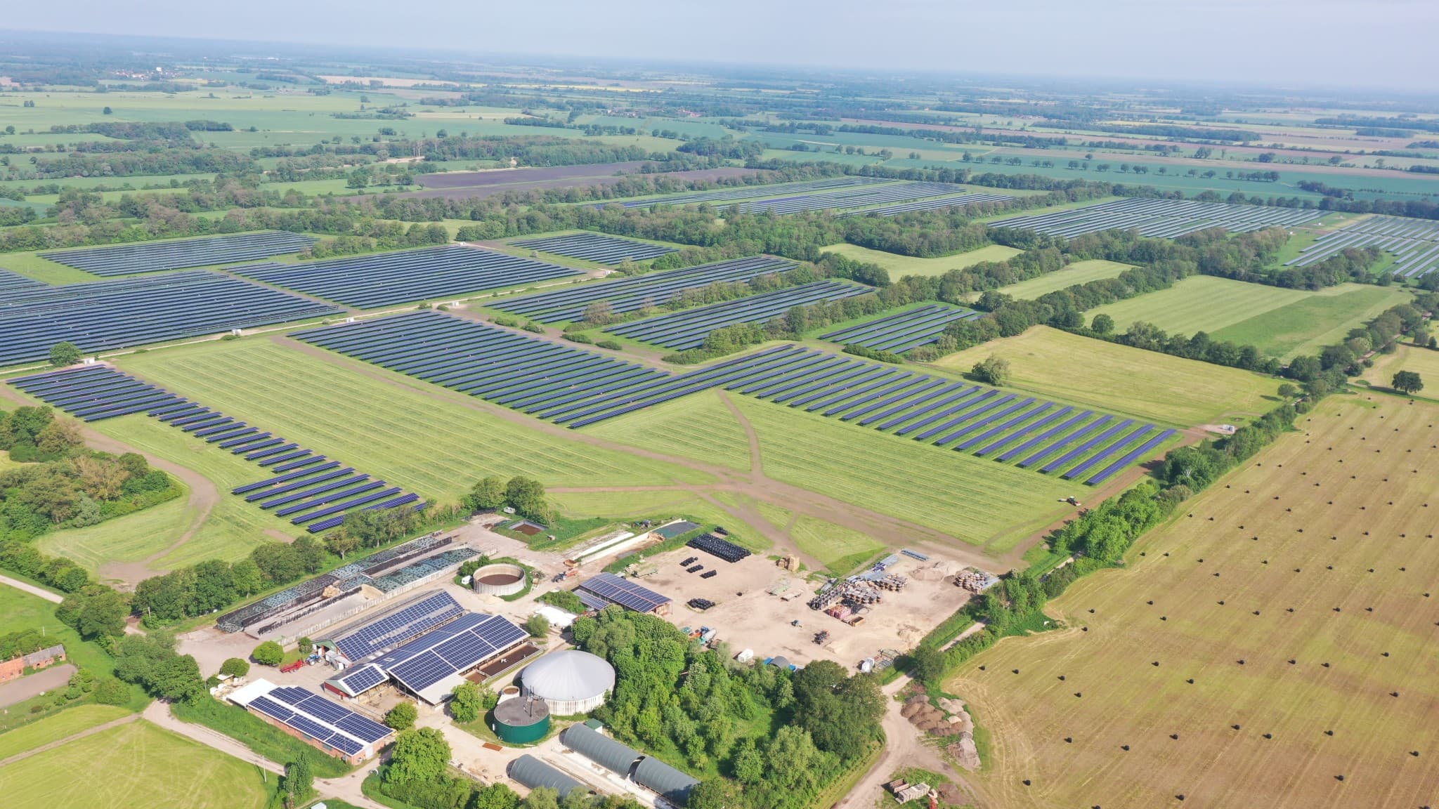 Luftaufnahme des 69 MWp Agri-PV-Parks in Schwarzholz, Sachsen-Anhalt mit Solarmodulen auf Feldern.