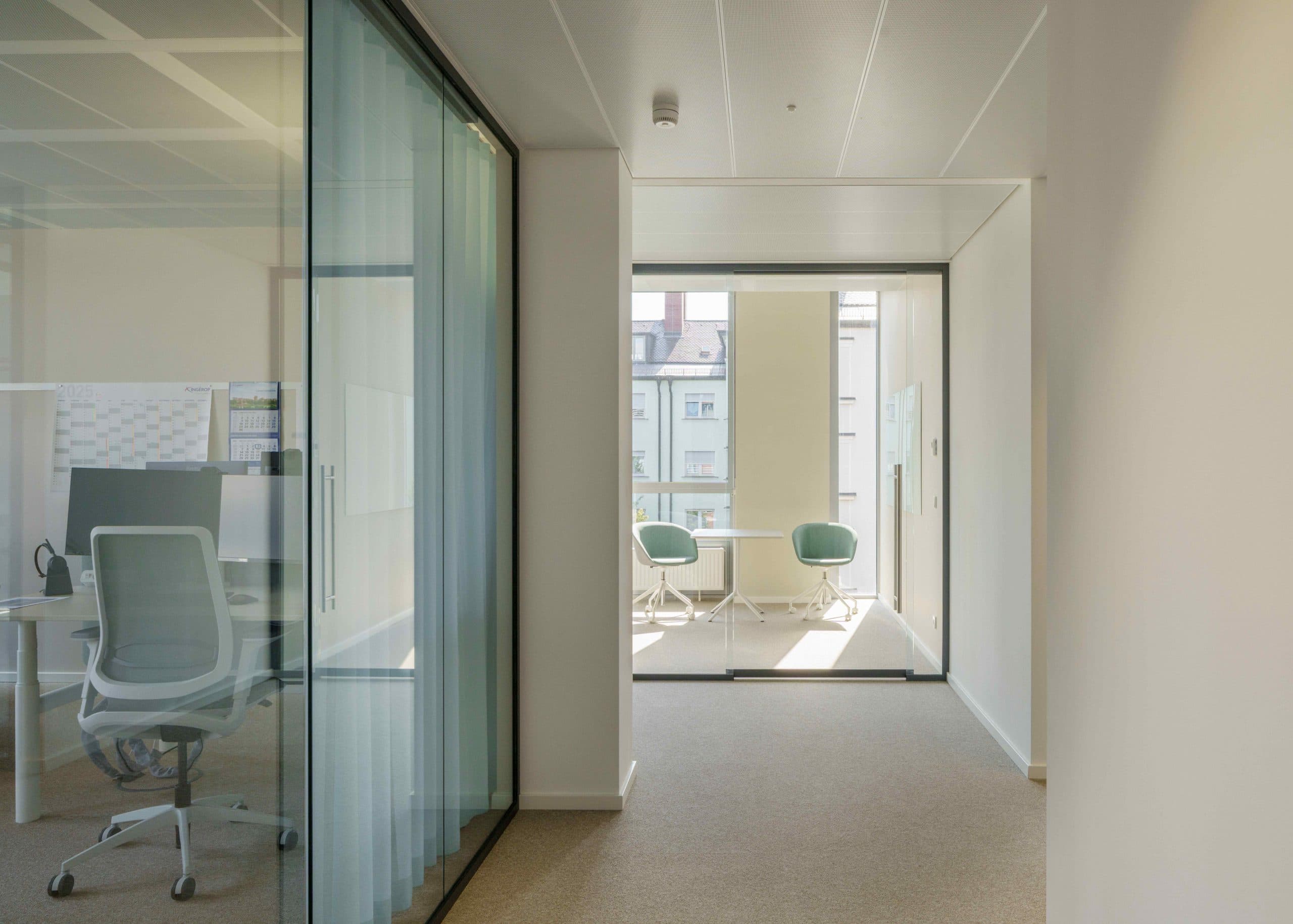 Moderne, helle Büroflächen im Gebäude Altezza in München mit Glaswänden und Besprechungsraum.
