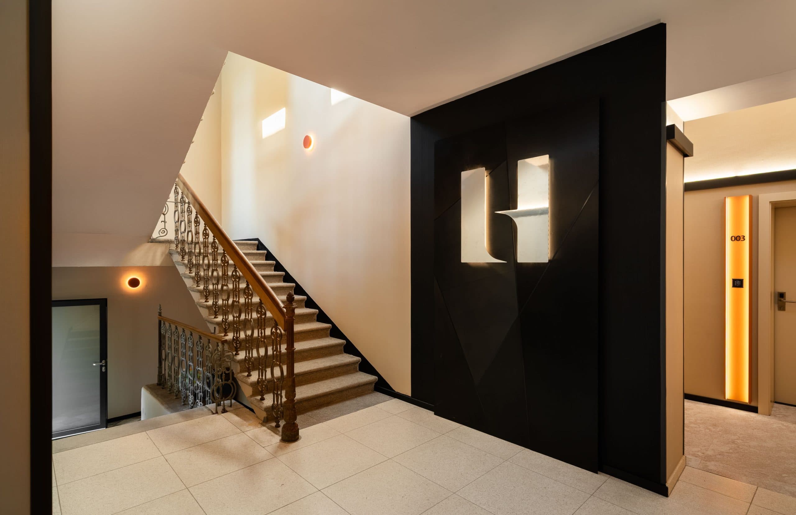 Moderner Eingangsbereich mit Treppenhaus im Limehome Linz Urfahr.