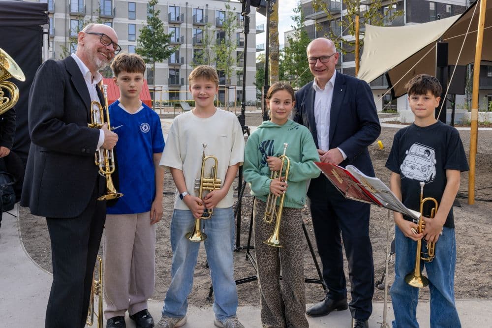 Berlins Regierender Bürgermeister Kai Wegner mit jungen Musikerinnen und Musikern des Neuköllner Blechblasorchesters bei der Eröffnung von Momento Berlin