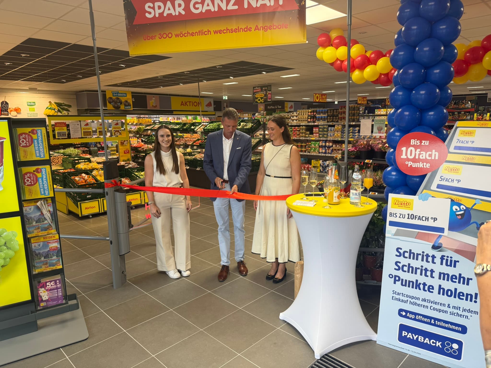 Feierliche Eröffnung mit Banddurchschnitt in der neuen Netto Marken-Discount Filiale in Frielendorf: Nadia Heider, Jens Nöll und Melissa Lind vor dem Obst- und Gemüseregal.