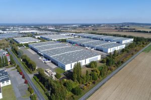 Luftaufnahme des SEGRO Logistics Park in Marly-la-Ville mit mehreren Logistikhallen im Grünen.