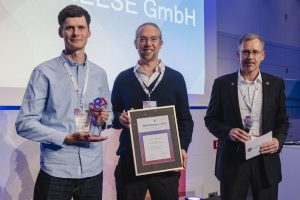 Gruppenfoto: Juri Kessler und Max Reder von AUKETT + HEESE mit Laudator bei der Verleihung zum BIM Champion 2026.