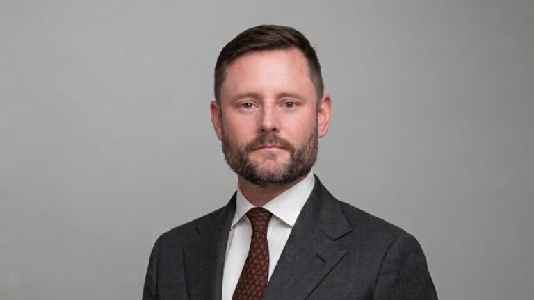 Christopher Lavery in Business-Anzug vor neutralem Hintergrund, Portrait für Colliers France