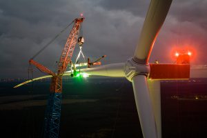 Kranmontage an Windenergieanlage im Windpark Mahlsdorf, Brandenburg, bei Dämmerung