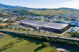 Luftbild des geplanten City Park Müllheim mit Industrie- und Logistikhalle von Panattoni, umgeben von Landschaft und Stadtansicht.