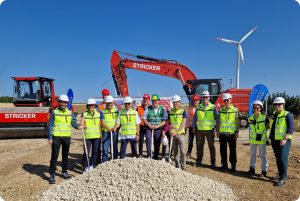 Gruppe von Personen beim symbolischen Spatenstich für das Repowering des Windparks Ingstetten in Baden-Württemberg, mit Baumaschinen und Windrad im Hintergrund.