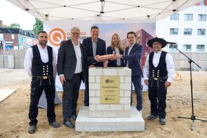 Gruppenfoto bei der Grundsteinlegung des Projekts Quartier Wandsbek Markt in Hamburg mit Vertretern von Union Investment, Politik und Handwerkern.