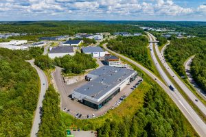 Luftbild einer Logistikimmobilie in Mölnlycke bei Göteborg, Schweden, umgeben von Wald und Straßen.