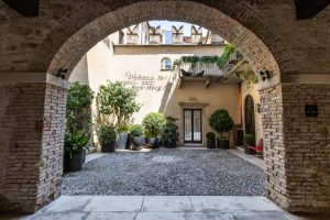Innenhof des historischen Palazzo Forti in Verona mit moderner Bepflanzung und restaurierter Fassade