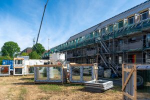 Baustelle mit neuer Wärmedämmung, Fensterelementen und Gerüst an einem Mehrfamilienhaus in Köln-Niehl