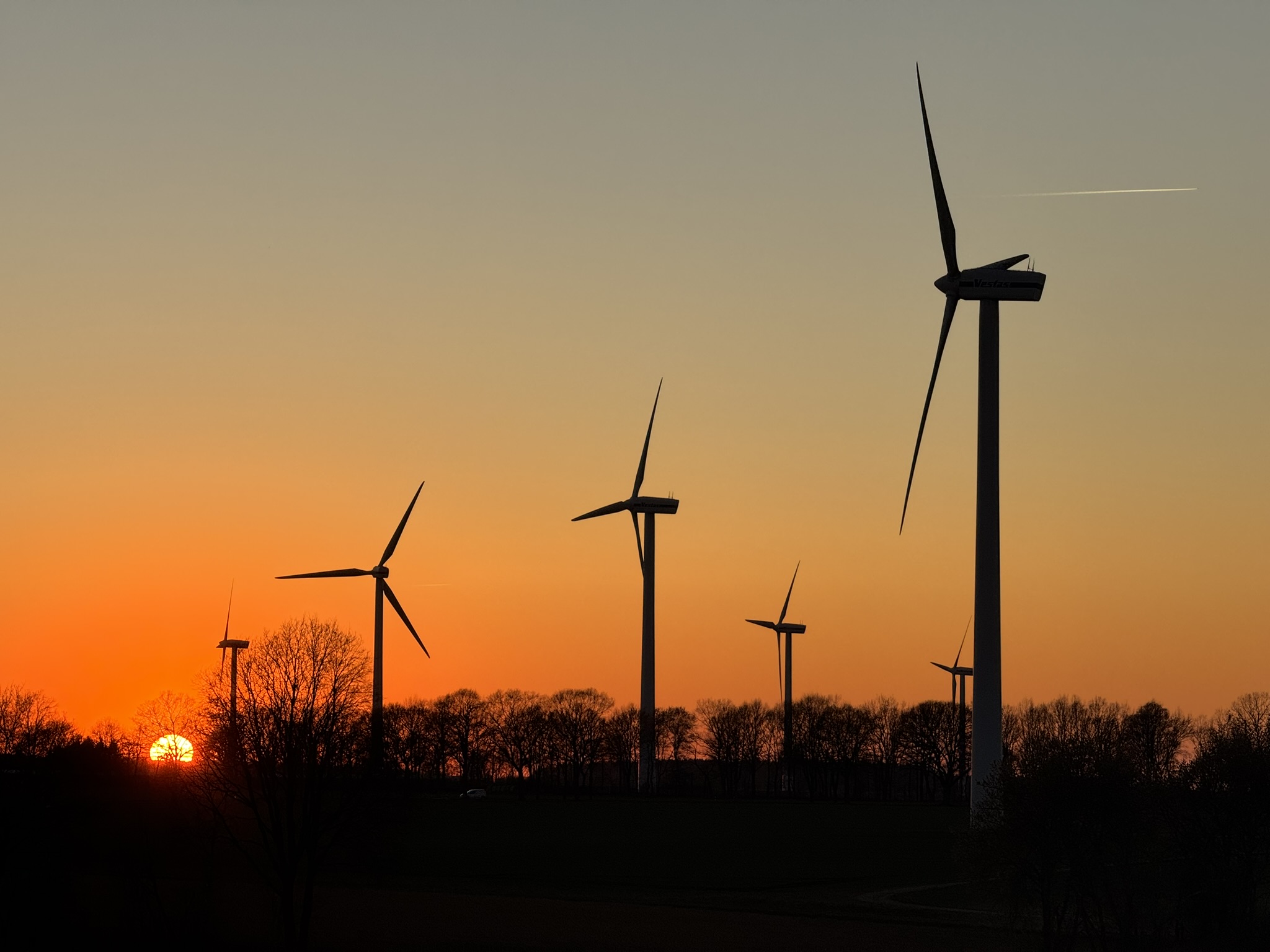Windräder des Navaris Windparks Apensen vor Sonnenuntergang