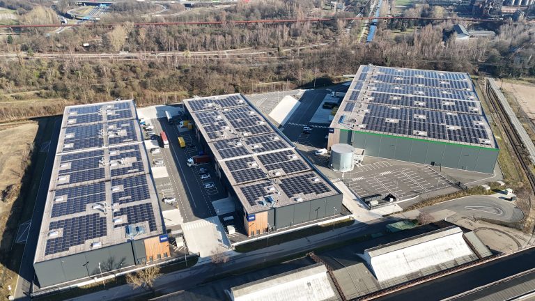 Luftaufnahme der drei modernen Gewerbegebäude des Multi-User-Parks in Duisburg-Meiderich mit großflächigen Photovoltaikanlagen auf den Dächern.
