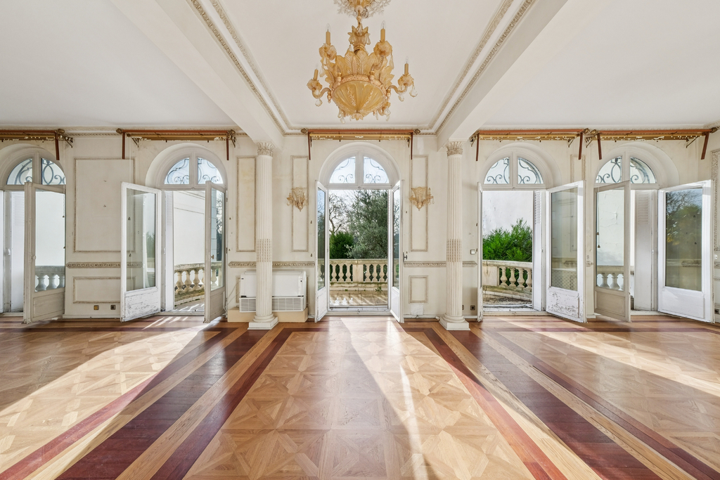 Innenansicht eines eleganten, hellen Raumes mit Parkett und großen Fenstern in einem Hôtel particulier in Neuilly-sur-Seine.