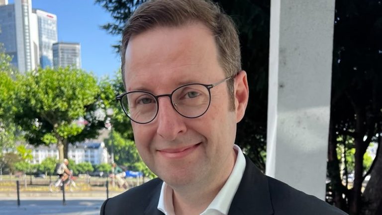 Peter Lausmann, neuer Head of Communications Germany bei Newmark, im Außenbereich mit Skyline im Hintergrund.