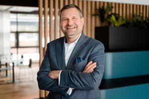 Marcel Wnendt, CEO/CFO von Bayerische Hausbau Real Estate, lächelt im modernen Büro.